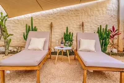 two chairs and a table in a room with plants at Walk to Beach - Hot Tub - Pool - Comfort & Space in Coco