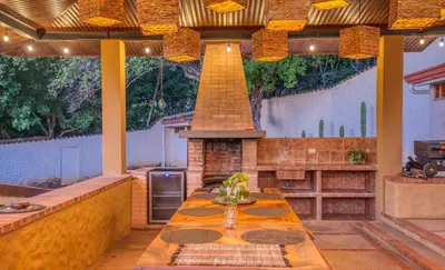 a outdoor kitchen with a table and a fireplace at Walk to Beach - Hot Tub - Pool - Comfort & Space in Coco
