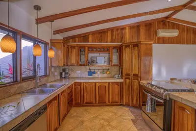 a kitchen with wooden cabinets and a sink at Walk to Beach - Hot Tub - Pool - Comfort & Space in Coco