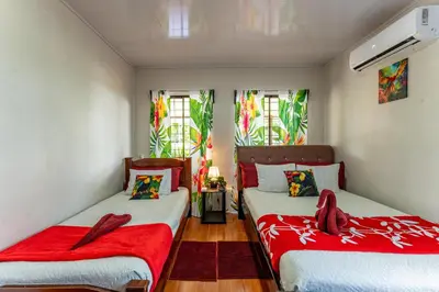 two beds in a room with red blankets at Toucan River Retreat - River Access, AC & Jacuzzi in San Francisco