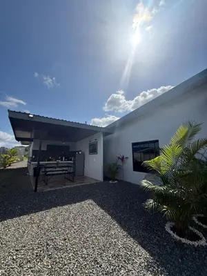 a white building with a bench in the yard at Arenal Star Luxury Studios with Private Jacuzzi in Fortuna