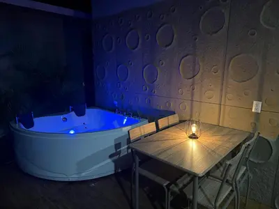 a room with a tub and a table with a candle at Arenal Star Luxury Studios with Private Jacuzzi in Fortuna