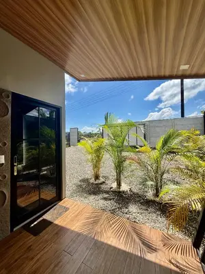 an open door of a house with palm trees at Arenal Star Luxury Studios with Private Jacuzzi in Fortuna