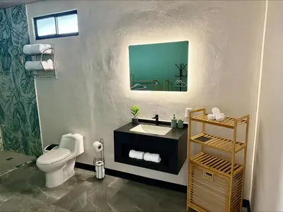 a bathroom with a white toilet and a sink at Arenal Star Luxury Studios with Private Jacuzzi in Fortuna
