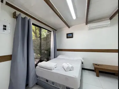 a small bedroom with a bed and a window at El Garden Santa Teresa Guesthouse in Santa Teresa Beach