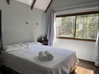 a bedroom with a bed with two towels on it at El Garden Santa Teresa Guesthouse in Santa Teresa Beach