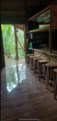 a row of wooden tables and chairs in a restaurant at Cabaña las Palmeras Pura Vida!! in Linda Vista