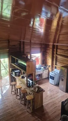 a kitchen with a counter and stools in a room at Cabaña las Palmeras Pura Vida!! in Linda Vista