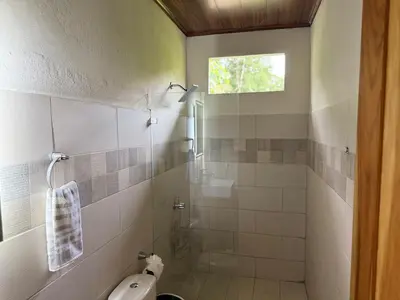 a bathroom with a toilet and a glass shower at Quiet, Affordable Casita Close to Surf & Nature - 15 minutes drive to Samara beach in Nandayure