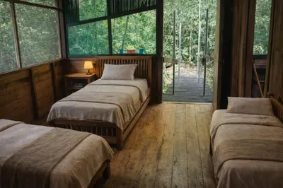 a bedroom with two beds in a room with windows at Jungle Overnight