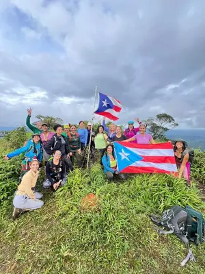 a group of people standing on a hill holding flags at Jungle Overnight