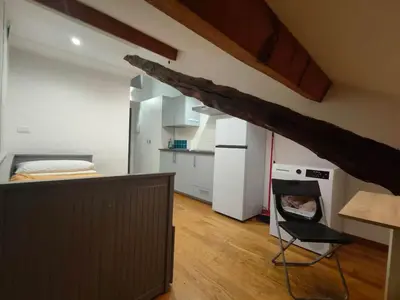 a kitchen with a bed and a chair in a room at Cozy Central Apartment in San José