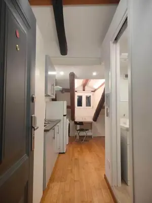 a room with a hallway with a kitchen and a staircase at Cozy Central Apartment in San José