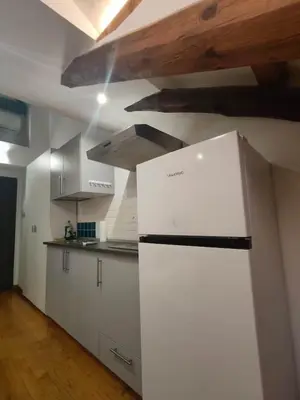 a kitchen with a white refrigerator in a room at Cozy Central Apartment in San José