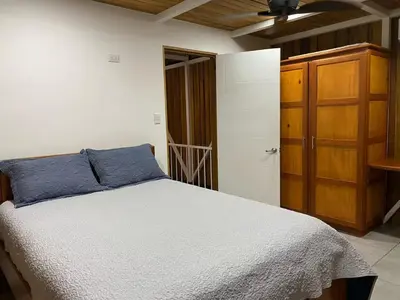 a bedroom with a bed and a wooden cabinet at Casa Pura Jungla in Santa Cruz