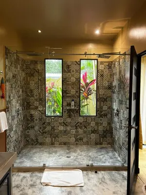 a bathroom with a shower with three windows at Villa Paraíso in Quepos