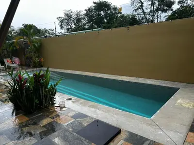 a swimming pool in a yard next to a fence at Villa Paraíso in Quepos