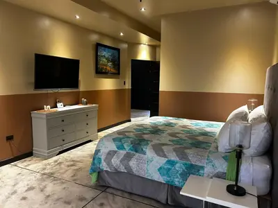a bedroom with a bed and a flat screen tv at Villa Paraíso in Quepos