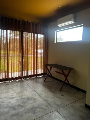 a room with large windows and a table in it at Villa Paraíso in Quepos