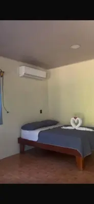 a bedroom with a large bed with a blue blanket at Hermosa House Tibas