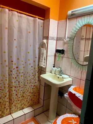 a bathroom with a shower curtain and a sink at Hermosa House Tibas