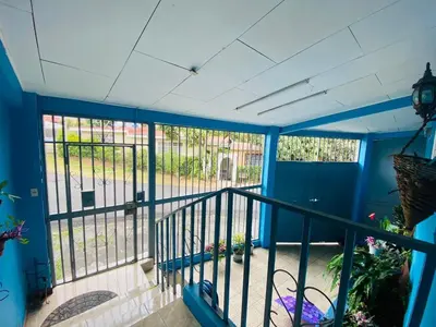 a view of a balcony with blue walls and a gate at Hermosa House Tibas