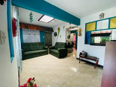 a living room with a green couch and a table at Hermosa House Tibas
