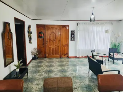 a living room with a large wooden door and chairs at Casa de Campo Arenal in San Francisco
