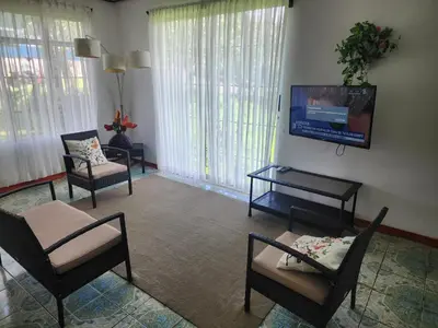 a living room with chairs and a flat screen tv at Casa de Campo Arenal in San Francisco
