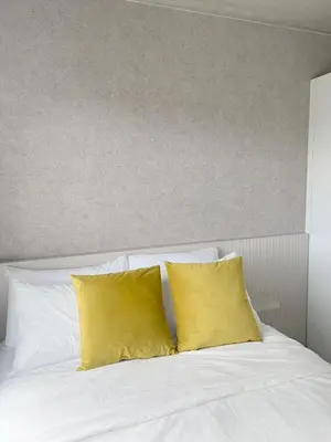 a white bed with two yellow pillows on it at Horizonte Al Este in Granadilla