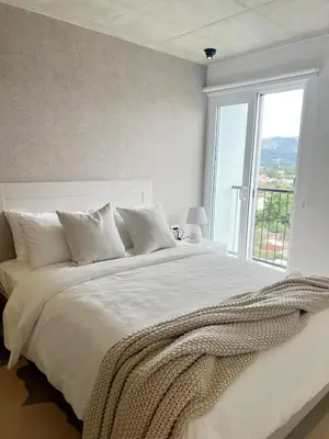 a white bedroom with a large bed with a window at Horizonte Al Este in Granadilla