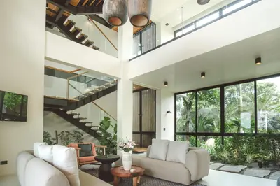 an open living room with white furniture and large windows at Casa Dominick - Luxury a short walk from the sea in Nosara