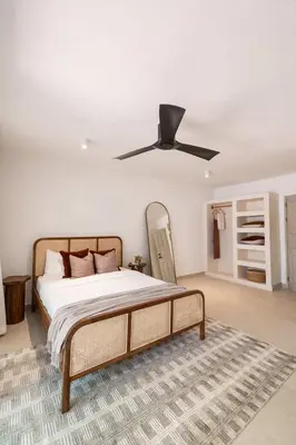 a bedroom with a bed with a ceiling fan at Villa Coro in Nosara