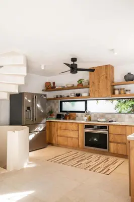 a kitchen with wooden cabinets and stainless steel appliances at Villa Coro in Nosara