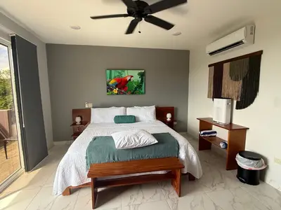 a bedroom with a bed and a ceiling fan at Hotel Las Lomas in Nandayure