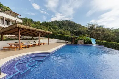 a swimming pool with a pavilion next to a house at Hotel Las Lomas in Nandayure