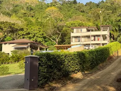 a house on the side of a road with a hedge at Hotel Las Lomas in Nandayure