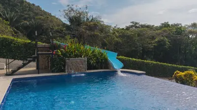 a swimming pool with a water slide at Hotel Las Lomas in Nandayure