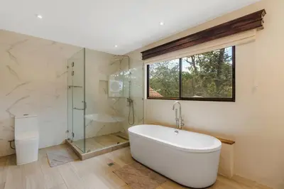 a bathroom with a tub and a glass shower at Elegant Surfside Retreat with Private Pool Spacious Outdoor Patio & Walkable Beach Access in Potrero