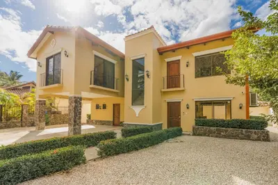 a yellow house with a driveway in front of it at Elegant Surfside Retreat with Private Pool Spacious Outdoor Patio & Walkable Beach Access in Potrero