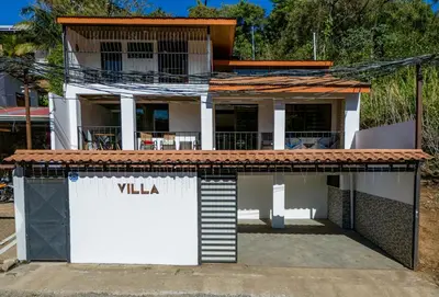 a white house with a sign that reads villa at Hostel Cocos B&B in Alajuela City