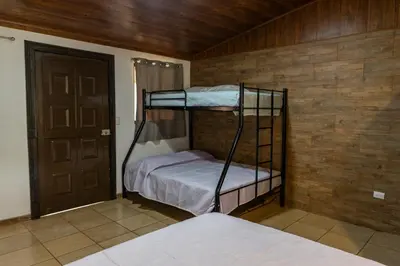 a room with two bunk beds and a door at Hostel Cocos B&B in Alajuela City