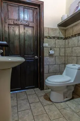 a bathroom with a toilet and a sink at Hostel Cocos B&B in Alajuela City