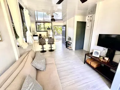 a living room with a couch and a flat screen tv at Piyiyo House 5 minutes from the beach walking in Uvita