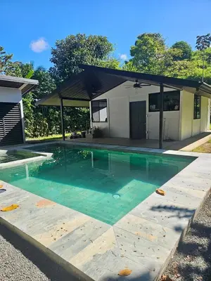 a swimming pool in front of a house at Piyiyo House 5 minutes from the beach walking in Uvita