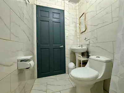 a bathroom with a toilet and a green door at Piyiyo House 5 minutes from the beach walking in Uvita