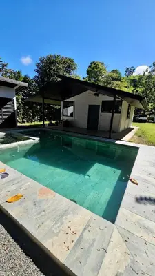 a swimming pool in front of a house at Piyiyo House 5 minutes from the beach walking in Uvita