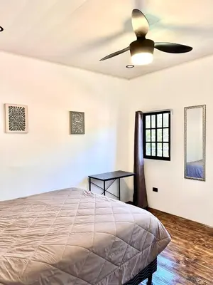 a bedroom with a bed and a ceiling fan at Minicasita Blanca in Uvita