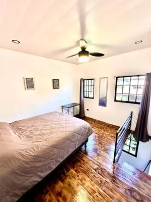 a bedroom with a bed and a ceiling fan at Minicasita Blanca in Uvita