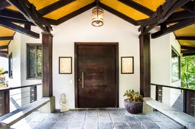 a hallway with a wooden door in a house at Tulemar Resort in Manuel Antonio